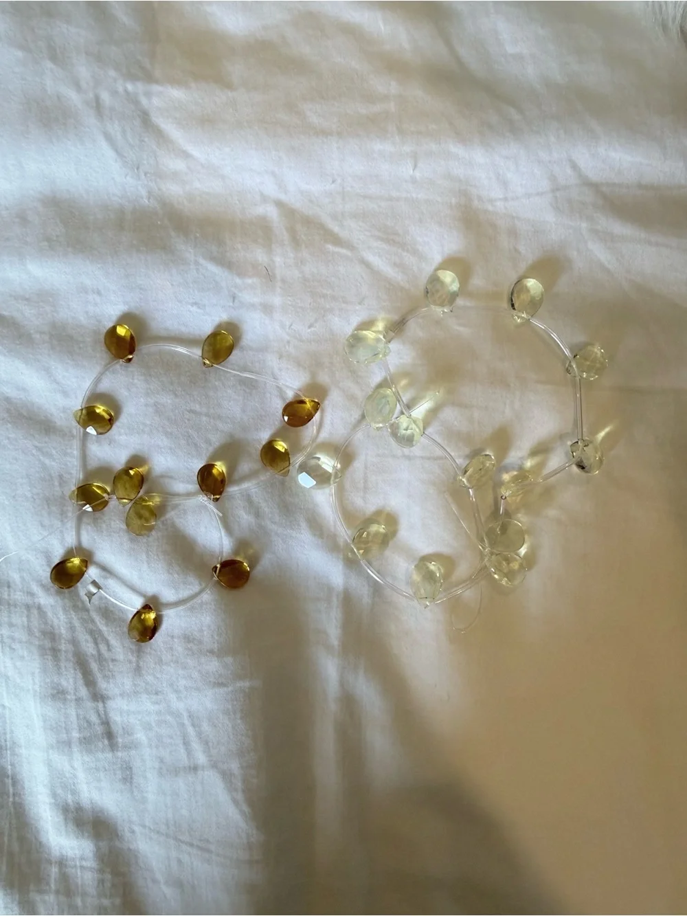 Two strands of faceted teardrop stones — pale yellow and amber color